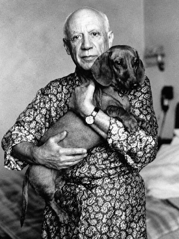 Pablo Picasso mit seinem Dackel Lump auf einem historischen Foto